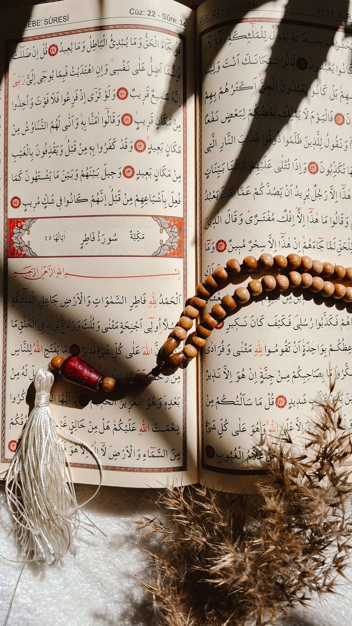 Holy Quran open with prayer beads in sunlight, Islamic spirituality focus.